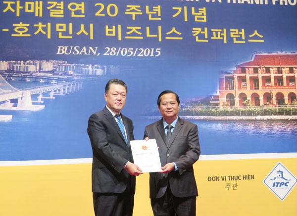 HCMC People’s Committee Deputy Chairman Nguyen Huu Tin (R) grants investment certificate to a Busan business (Photo: SGGP) HCMC People’s Committee Deputy Chairman Nguyen Huu Tin (R) grants investment certificate to a Busan business (Photo: SGGP)